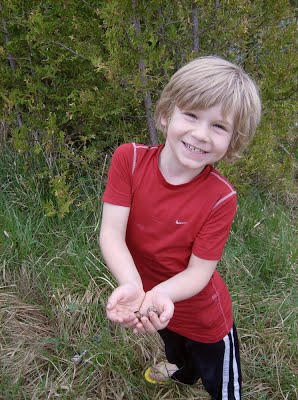 photo of young boy holding snails